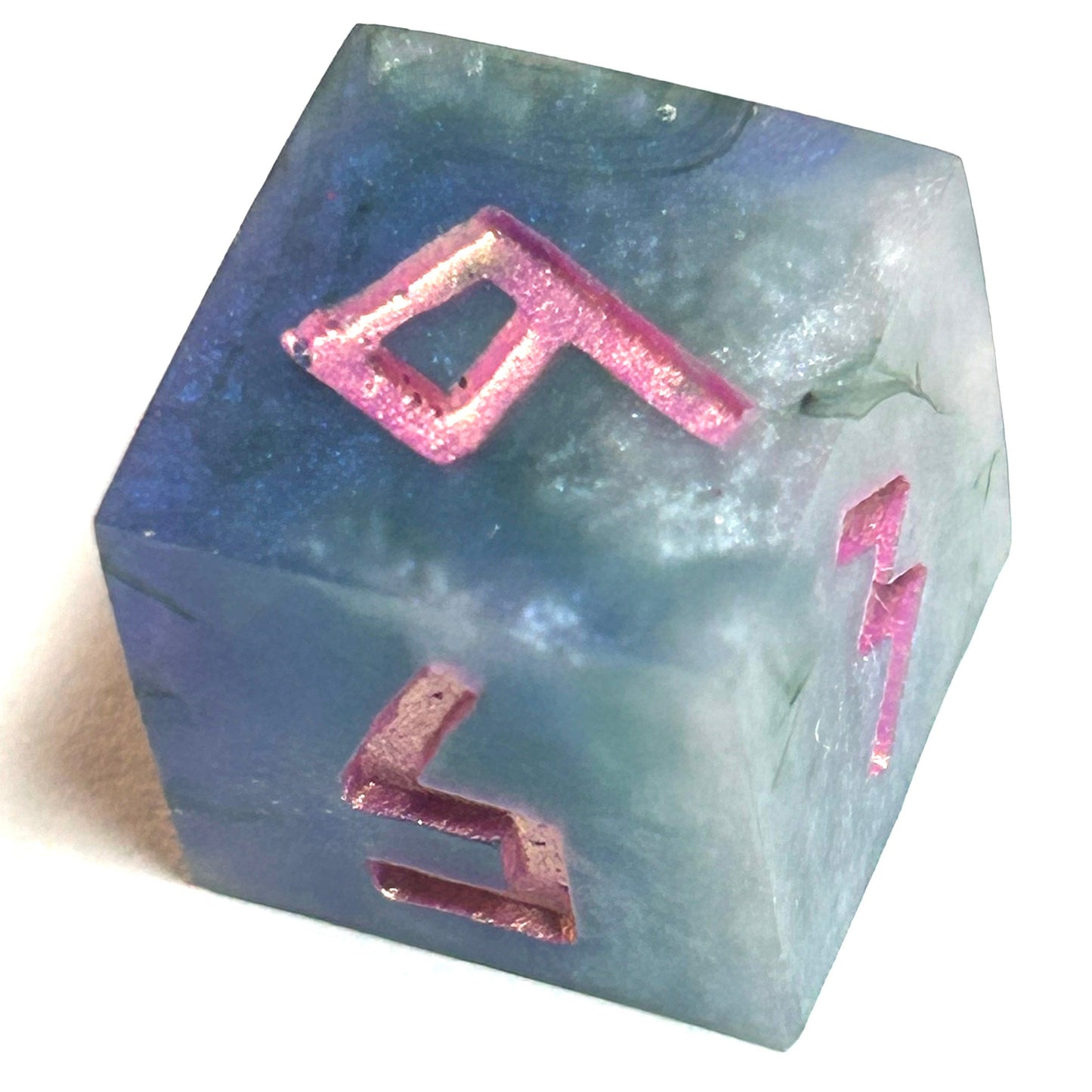 Close-up of D6 die from the Embermist handmade resin dice set, showing deep blue resin with shimmering rose engraved numbers.