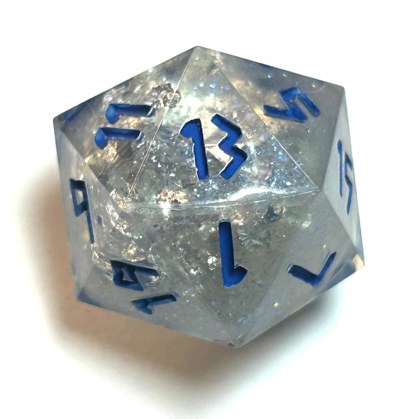Clear resin d20 with silver shimmer and deep blue numbering, resembling fractured ice — Infernal Crafts Glacial Veil handmade resin dice