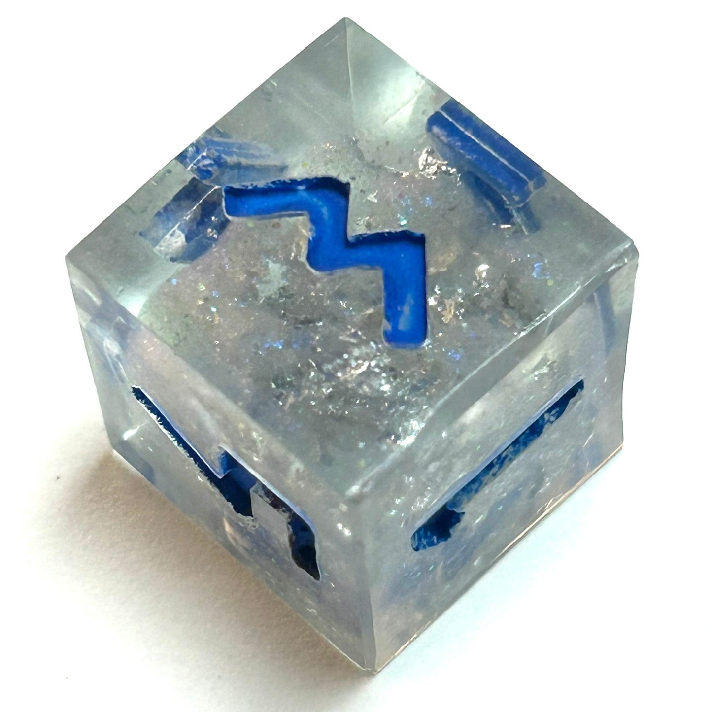 Clear resin d6 with silver shimmer and deep blue numbering, resembling fractured ice — Infernal Crafts Glacial Veil handmade resin dice