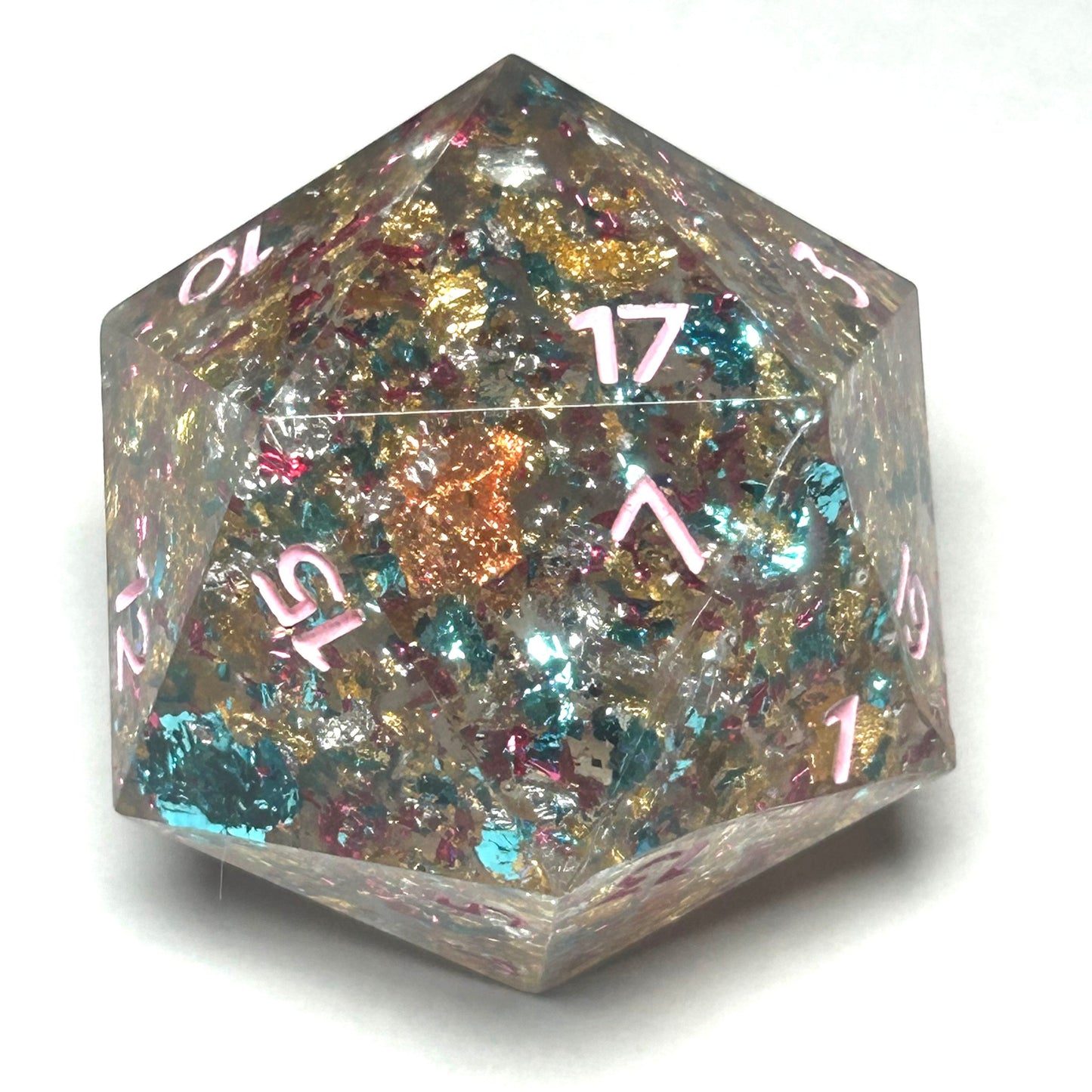 Resin D20 die with shimmering metallic foil in gold, teal, pink, and copper, featuring pink numbers.