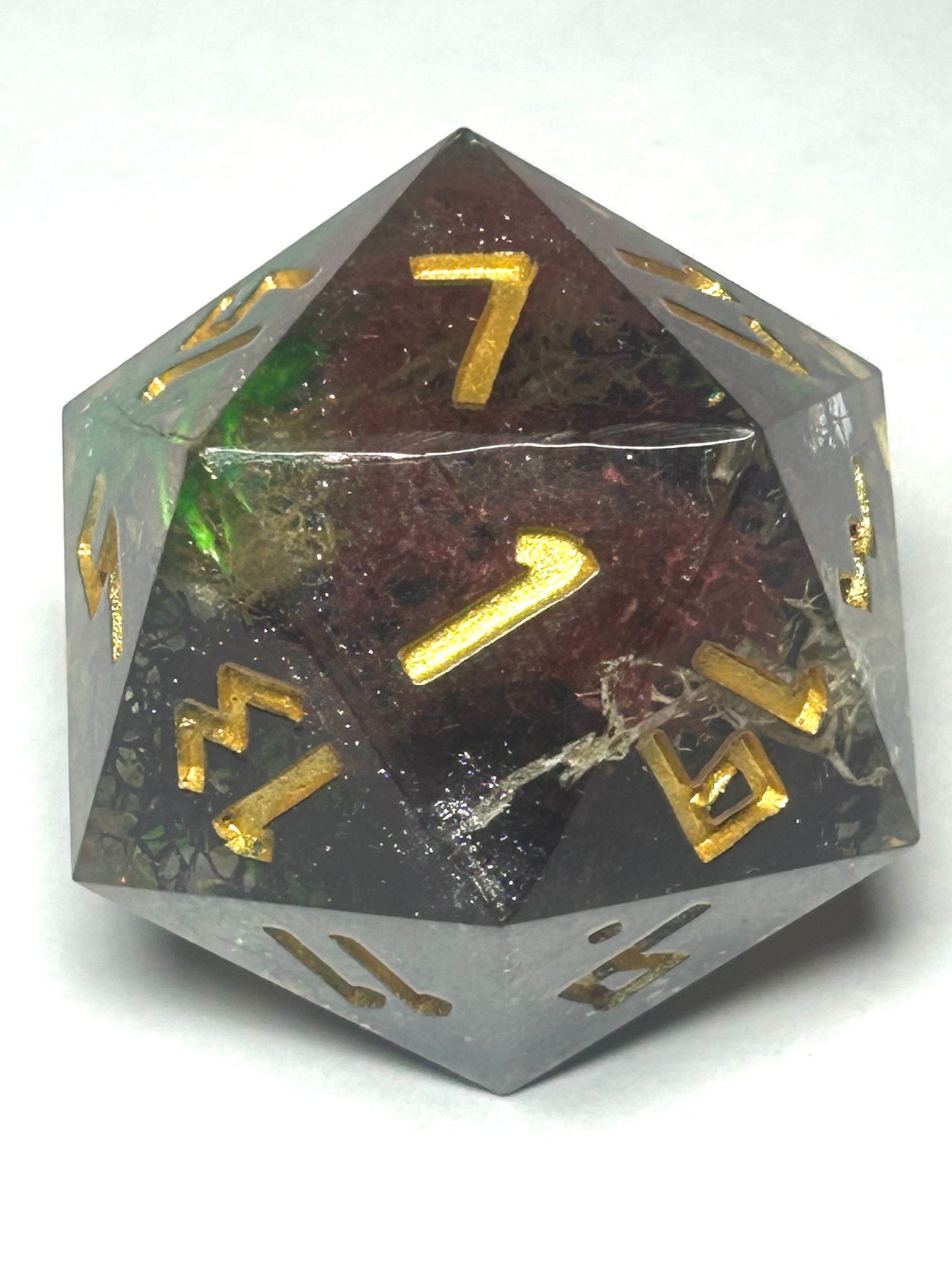 Large 35mm chonk D20 featuring a natural moss theme inside clear resin with shimmering gold numbering.