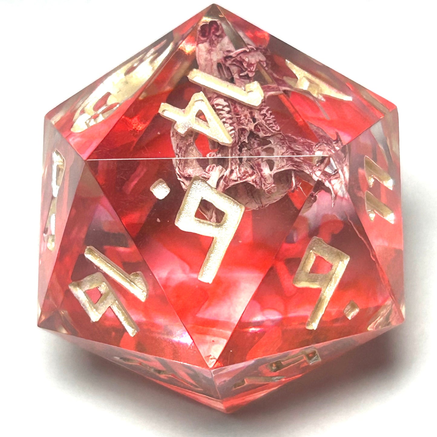 Close-up of a large 35mm resin D20 called Blood in the Water, showing real mouse bones preserved in translucent crimson resin with shimmering gold numbers.