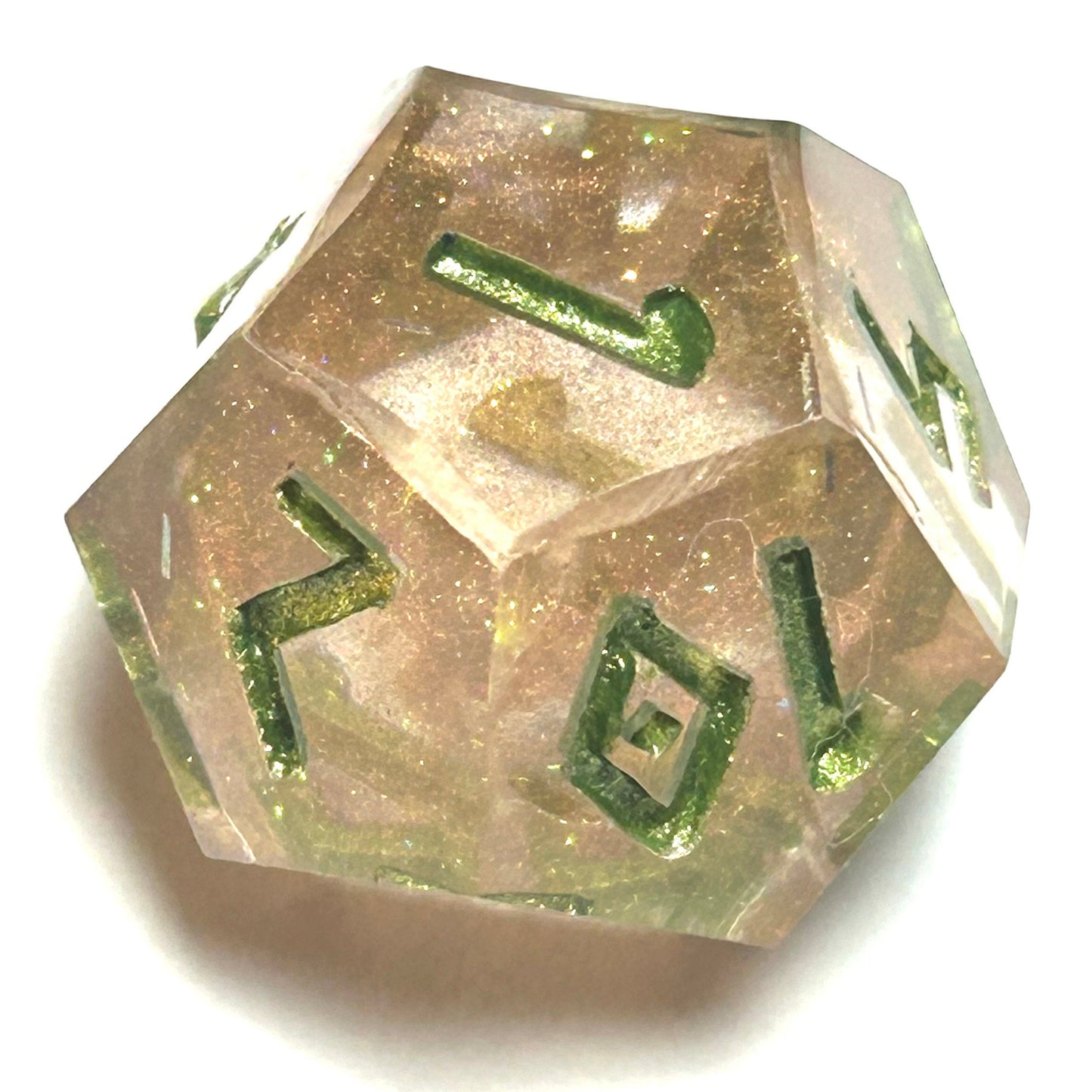 Close-up of D12 die from the Verdigrace handmade resin dice set with warm pink-gold shimmer and deep green numbering