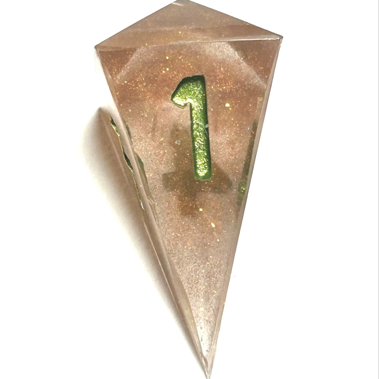 D4 die from the Verdigrace handmade resin dice set, with warm golden resin and a gleaming green number four