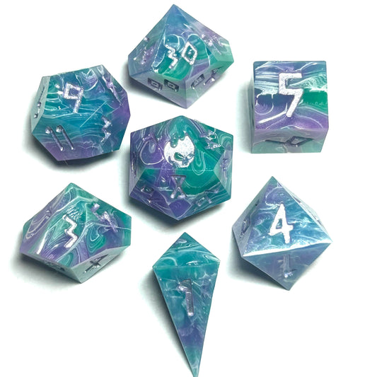 Handmade 7-piece teal and purple resin dice set for RPGs, with swirling ocean-like patterns and silver numbers.