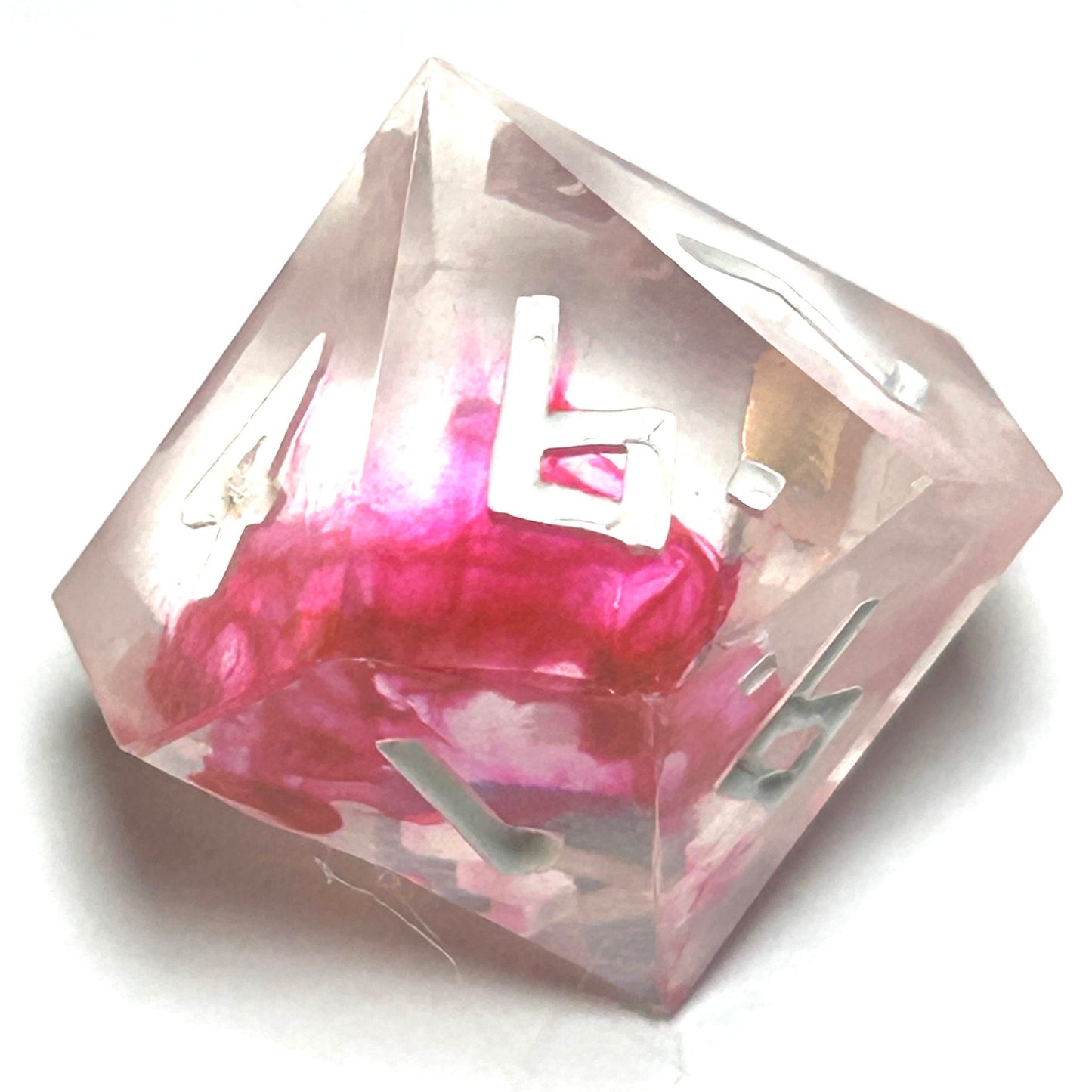 Close-up of the D10 from the Heartbreaker handmade resin dice set showing transparent resin with red pigment clouds and bright white numbers