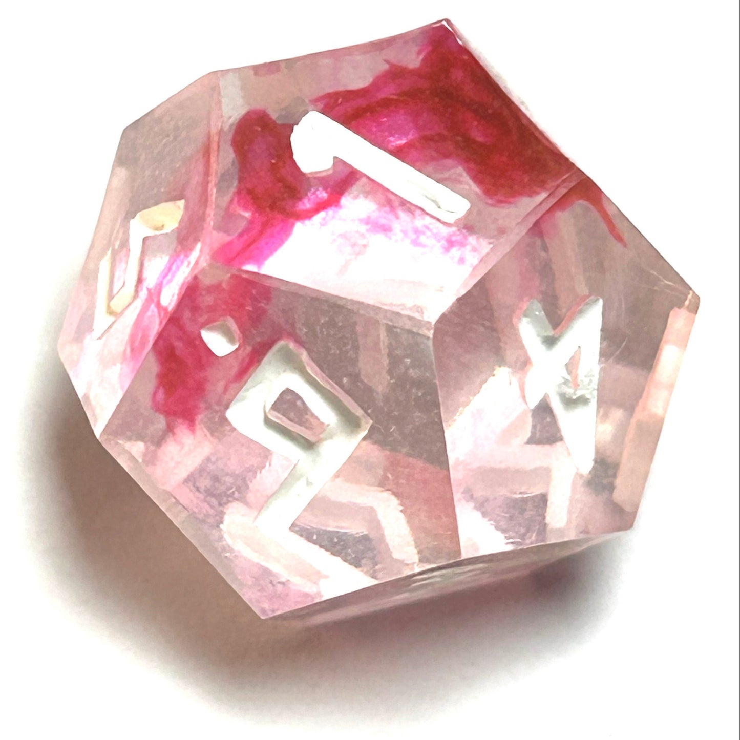 D12 die from the Heartbreaker handmade resin dice set with soft red swirls in clear resin and vivid white engraved numbers