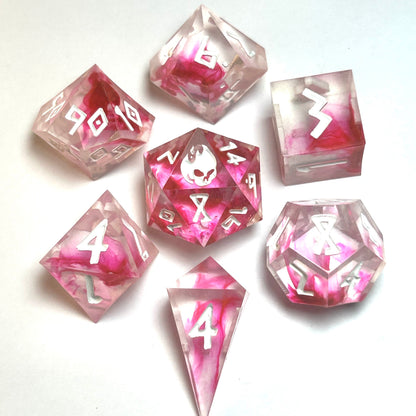 Heartbreaker handmade resin dice set from the Blood in the Water line — translucent clear resin with vivid crimson swirls and white numbering, full 7-piece polyhedral set by Infernal Crafts