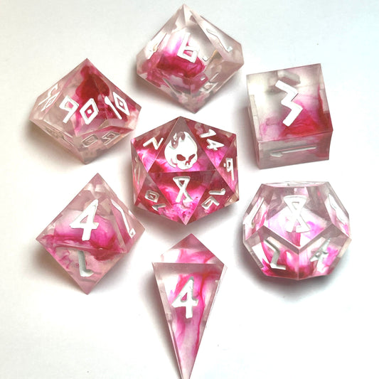 Heartbreaker handmade resin dice set from the Blood in the Water line — translucent clear resin with vivid crimson swirls and white numbering, full 7-piece polyhedral set by Infernal Crafts