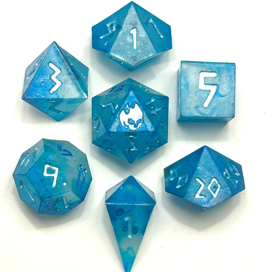 A full 7-piece set of handmade blue epoxy resin dice with white numbering, including d4, d6, d8, d10, d10, d12, and d20, arranged neatly on a white background.